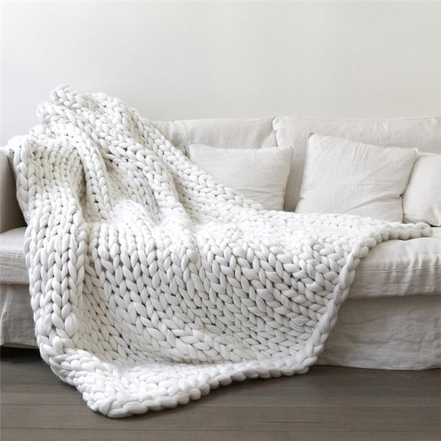 Knit throw blanket with looped texture draped over a sofa