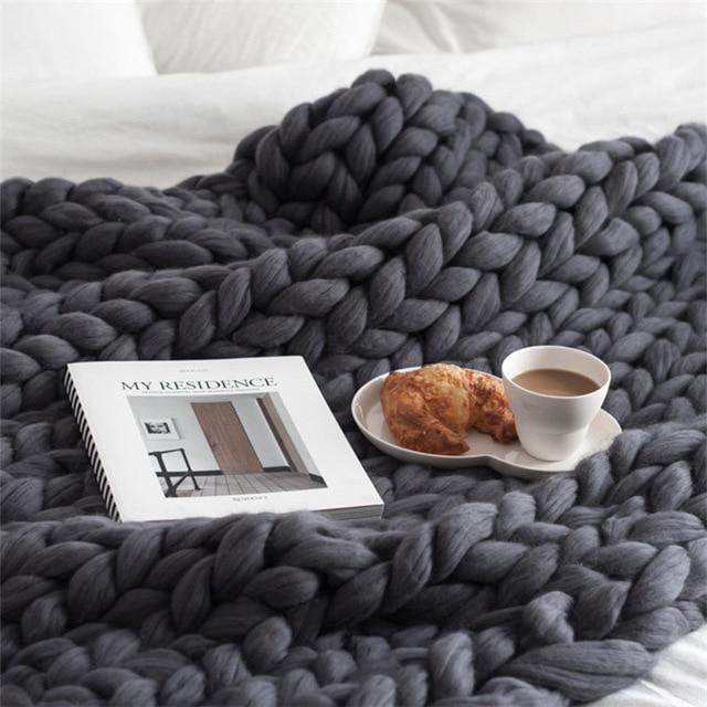 Knit throw blanket with oversized loop stitch folded on a surface