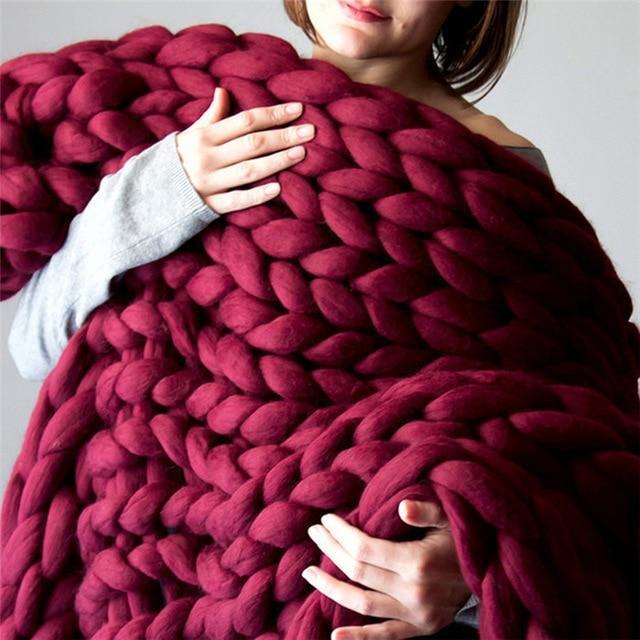 Close-up of a knit throw blanket with thick looped texture held in hands