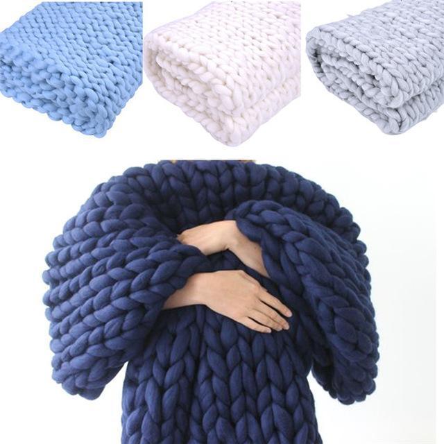 Knit throw blankets in multiple shades displayed in a cocoon wrap style
