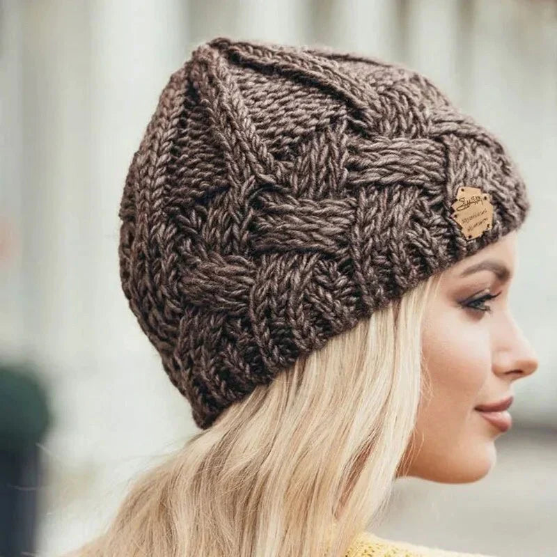 Brown chunky knit beanie featuring a thick cable-knit design and logo patch.
