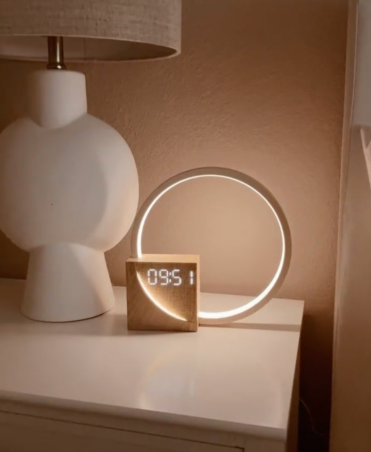 Plastic LED ring alarm clock with circular light frame and digital display, tabletop use