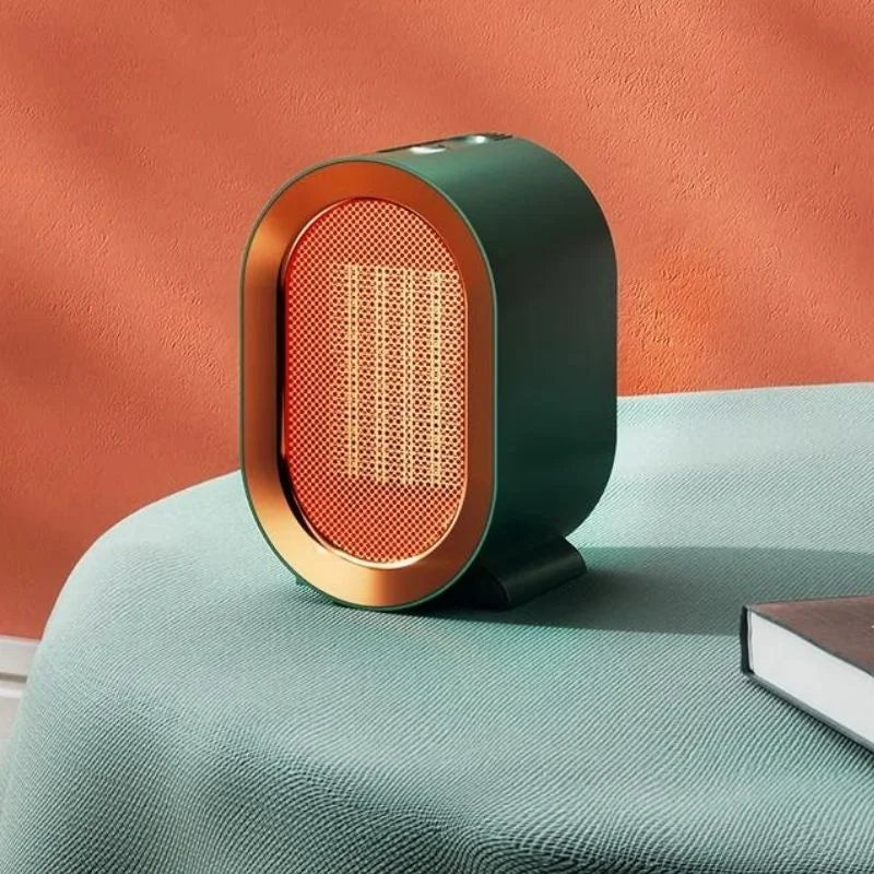 Compact electric space heater in dark green with gold trim on a table