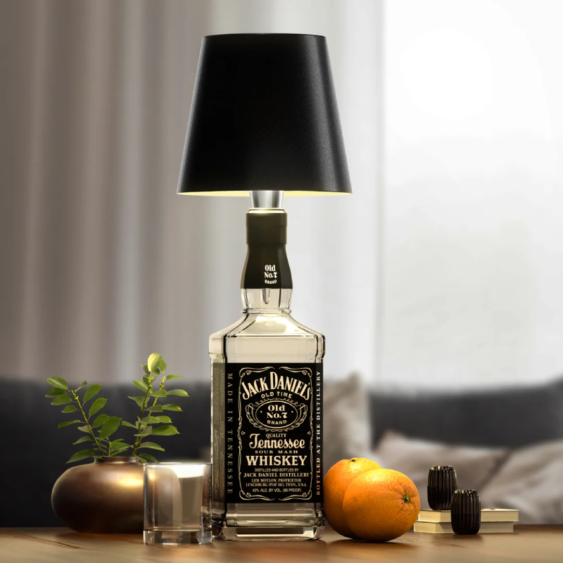 Bottle-shaped table lamp with a Jack Daniel’s style bottle base and a black lampshade.