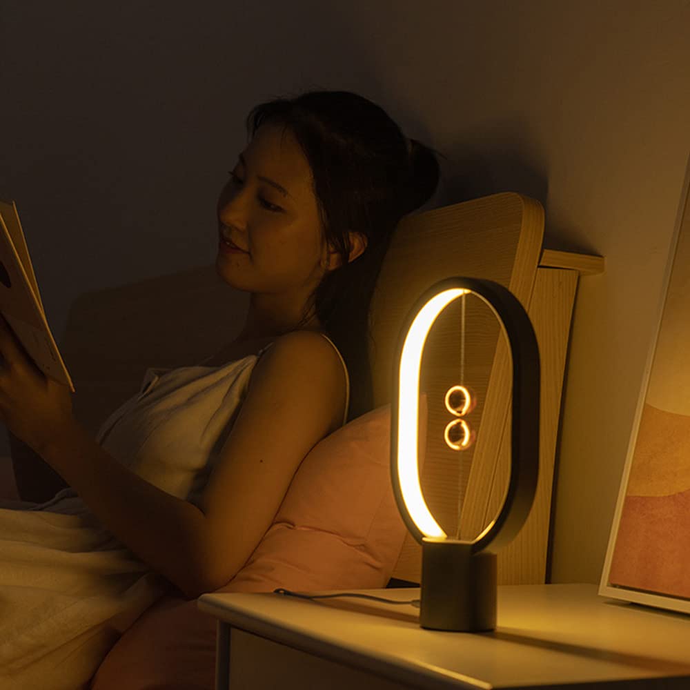 Oval LED bedside table lamp glowing warm light on a nightstand