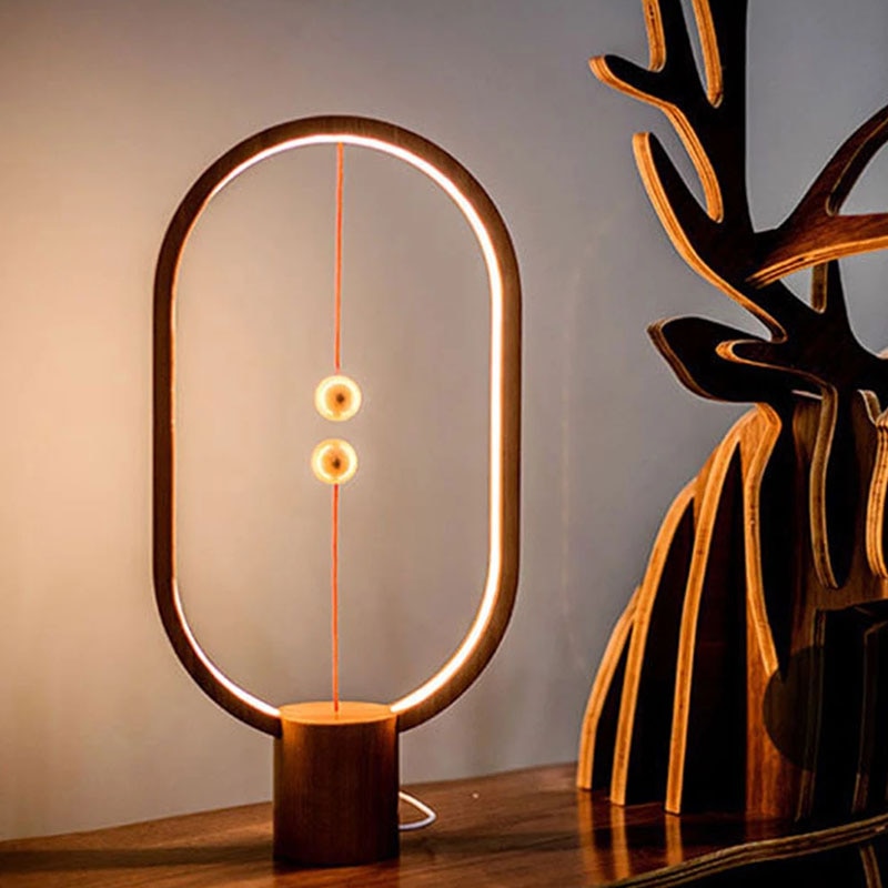 Modern oval LED table lamp with warm lighting and sculptural design