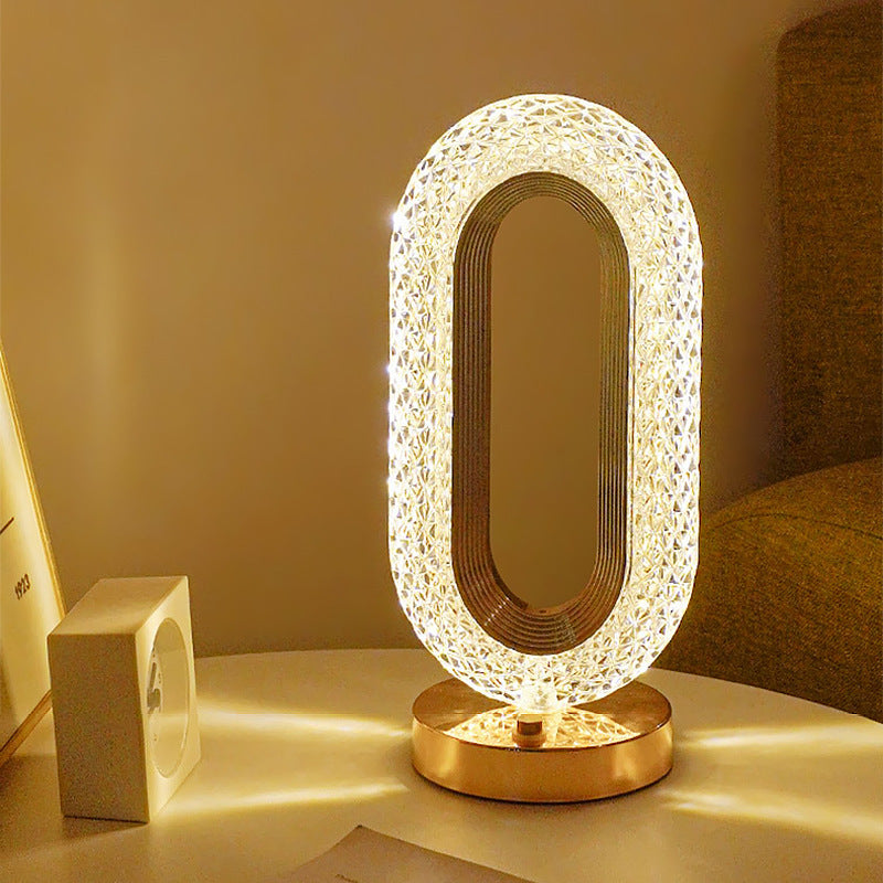 Modern oval crystal-style LED table lamp with gold base, warm ambient glow