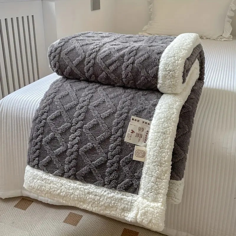 Dark grey plush sherpa blanket with cable knit texture and white trim.