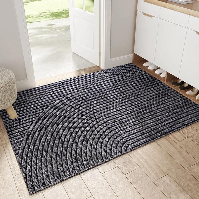 Dark grey textured entryway rug with curved line pattern in a hallway.
