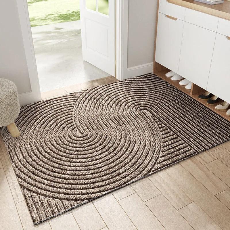 Beige textured entryway rug with circular swirl pattern in a hallway.